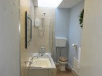 Light bathroom with WC and shower over bath