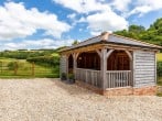 Oak framed open sided summerhouse with a table tennis table, seating and a fridge Oak framed open sided summerhouse with a table tennis table, seating and a fridge