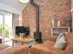 Cosy lounge area with woodburner and doors into garden