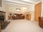A cosy lounge with characterful beams and a warming electric fire A cosy lounge with characterful beams and a warming electric fire