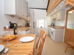 A well-equipped kitchen/diner with a light and airy feel and stairs to gallery