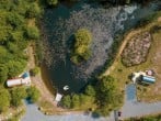 Aerial view of the lake and both pods with on-site parking along side Aerial view of the lake and both pods with on-site parking along side